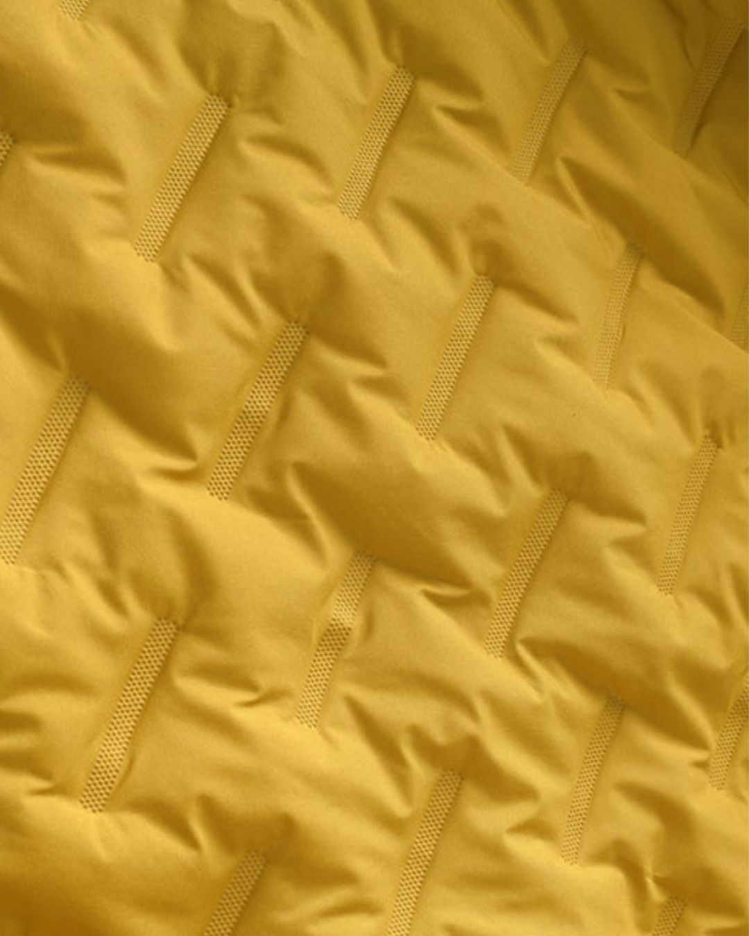 Close-up of yellow insulated windbreaker jacket lining with quilted interior texture
