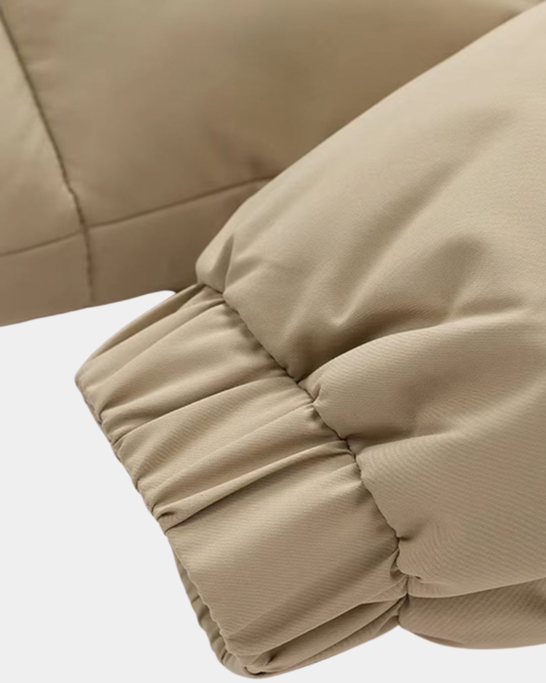 Close-up of a beige men’s winter puffer jacket sleeve featuring an elasticated cuff for warmth.