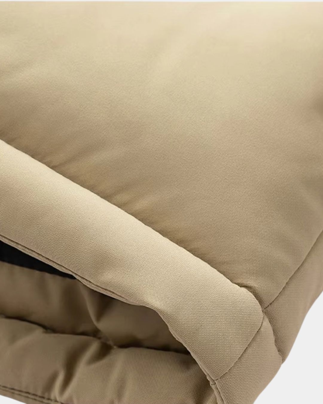 Close-up of a beige insulated men’s puffer jacket featuring smooth fabric texture and padded construction.
