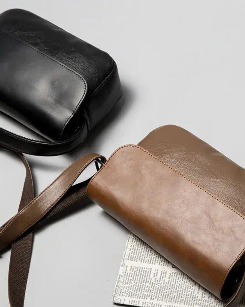 Torino men's crossbody bags in black and brown laid flat with canvas shoulder straps