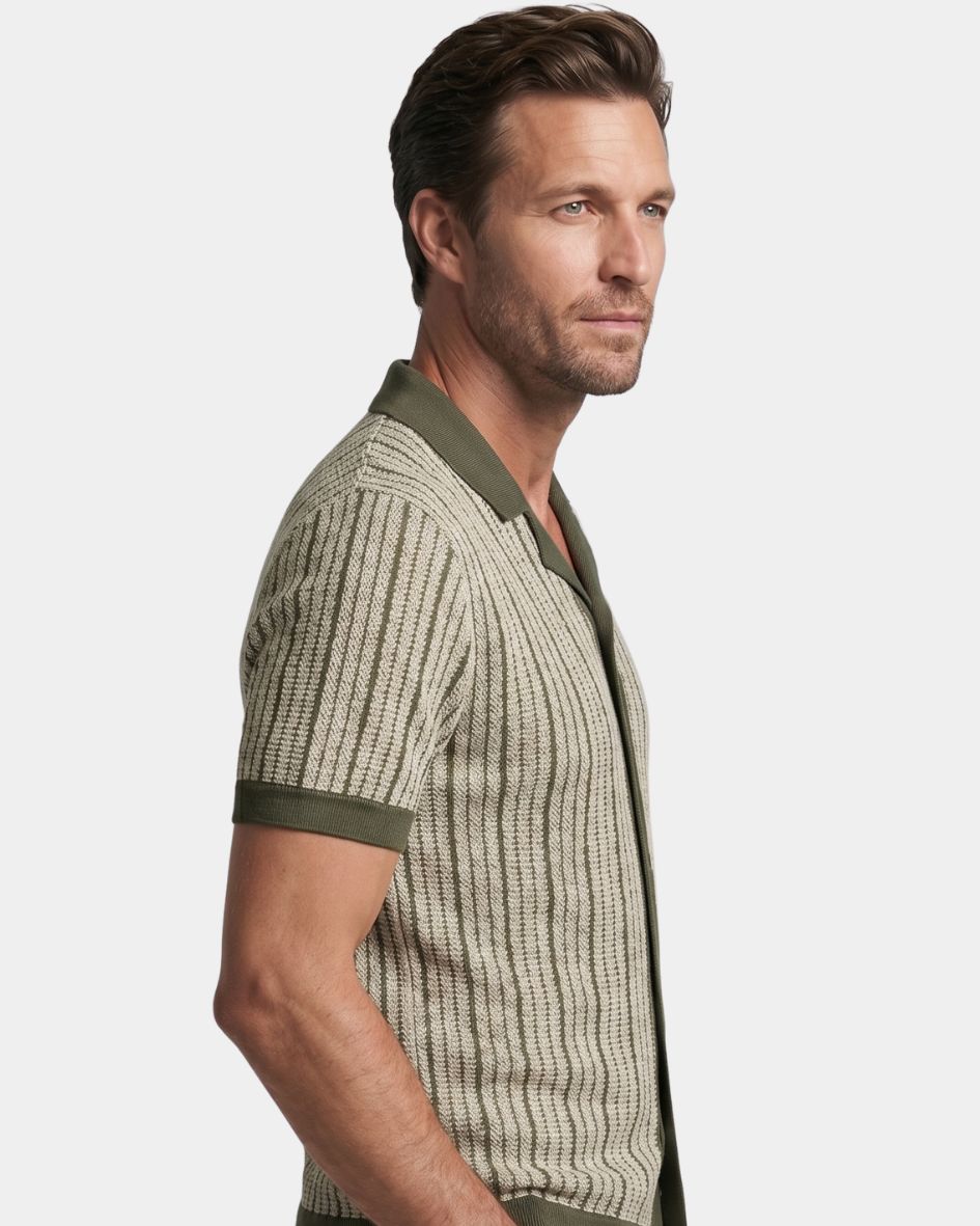 Man wearing a patterned shirt with green accents on a light gray background
