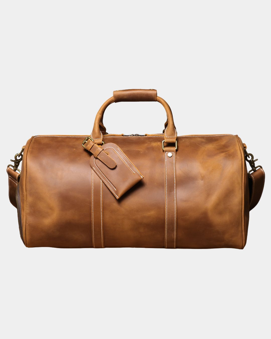 Front view Men's brown crazy horse leather duffel bag with luggage tag and crossbody strap by Hudson & Tate.