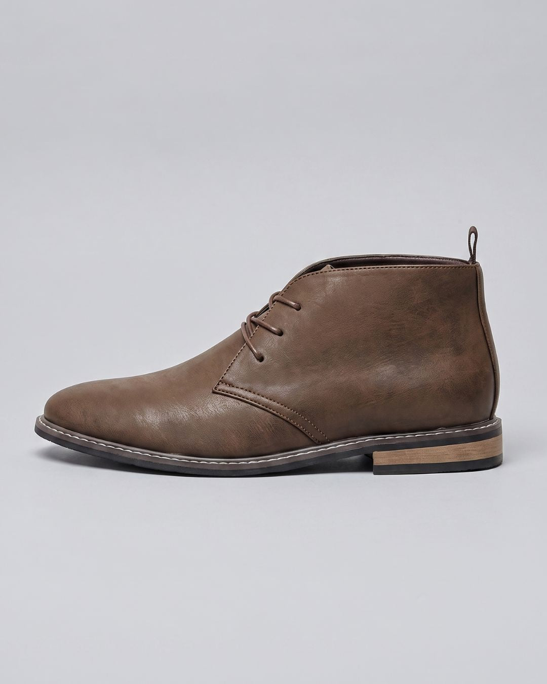 A brown leather lace-up chukka boot with a low stacked heel and contrast stitching, by Hudson & Tate.