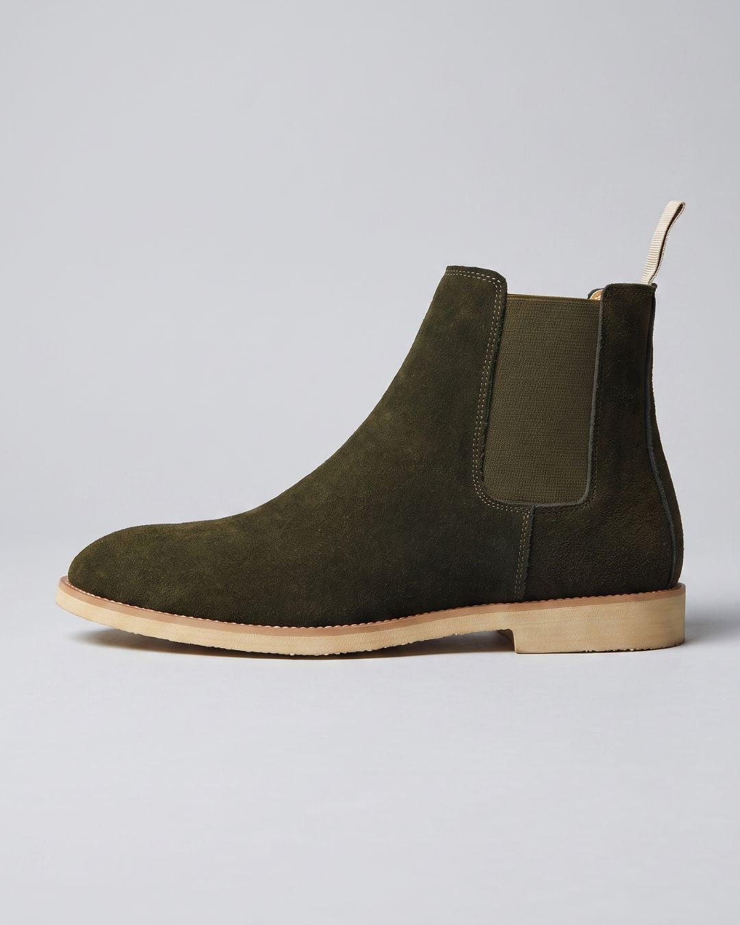 An olive green suede Chelsea boot with a tan sole, shown in a side profile against a light gray background.