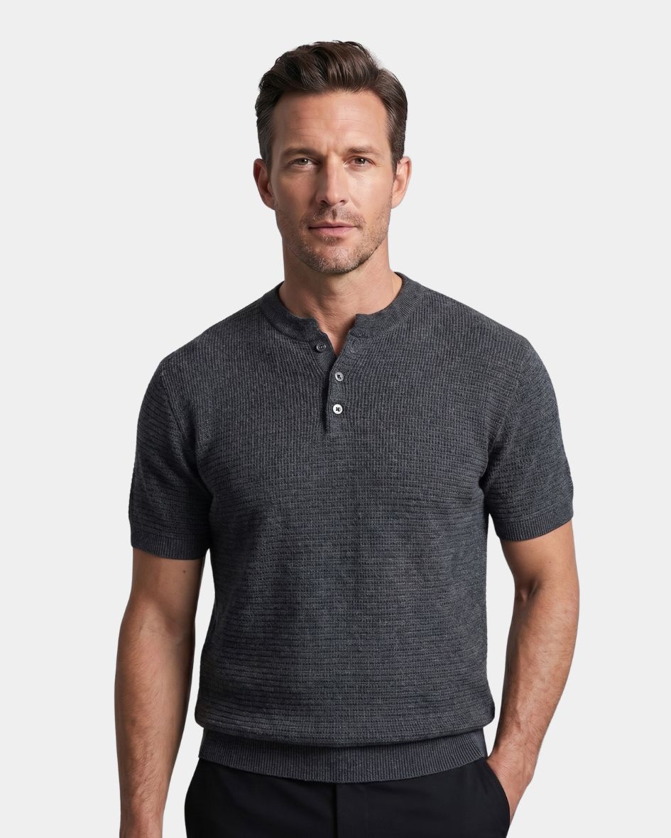 Man wearing a dark gray henley shirt against a light gray background