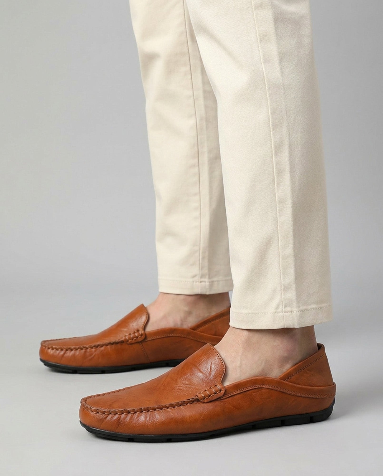 Beckett men's cognac leather driving loafers worn with beige trousers