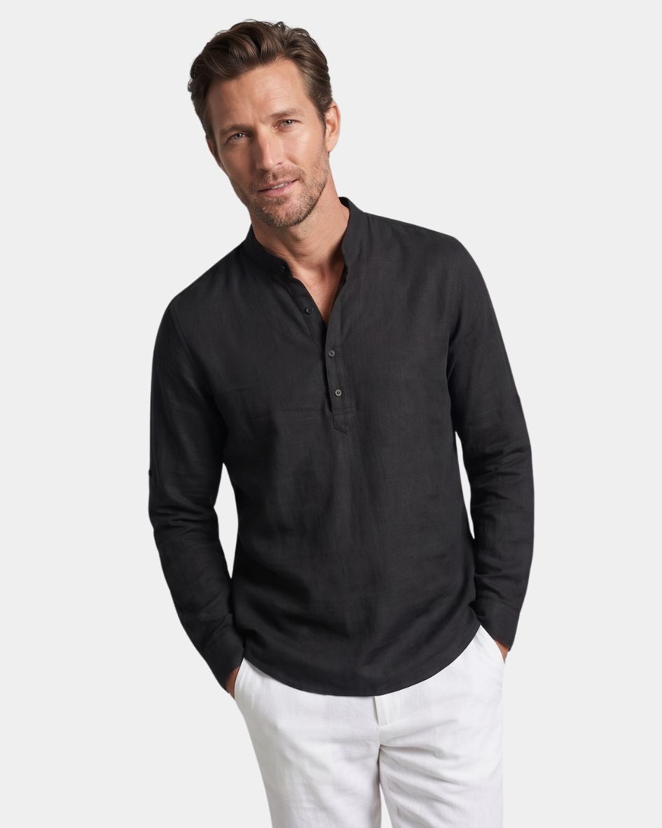 Man wearing a black long-sleeve shirt and white pants on a light gray background