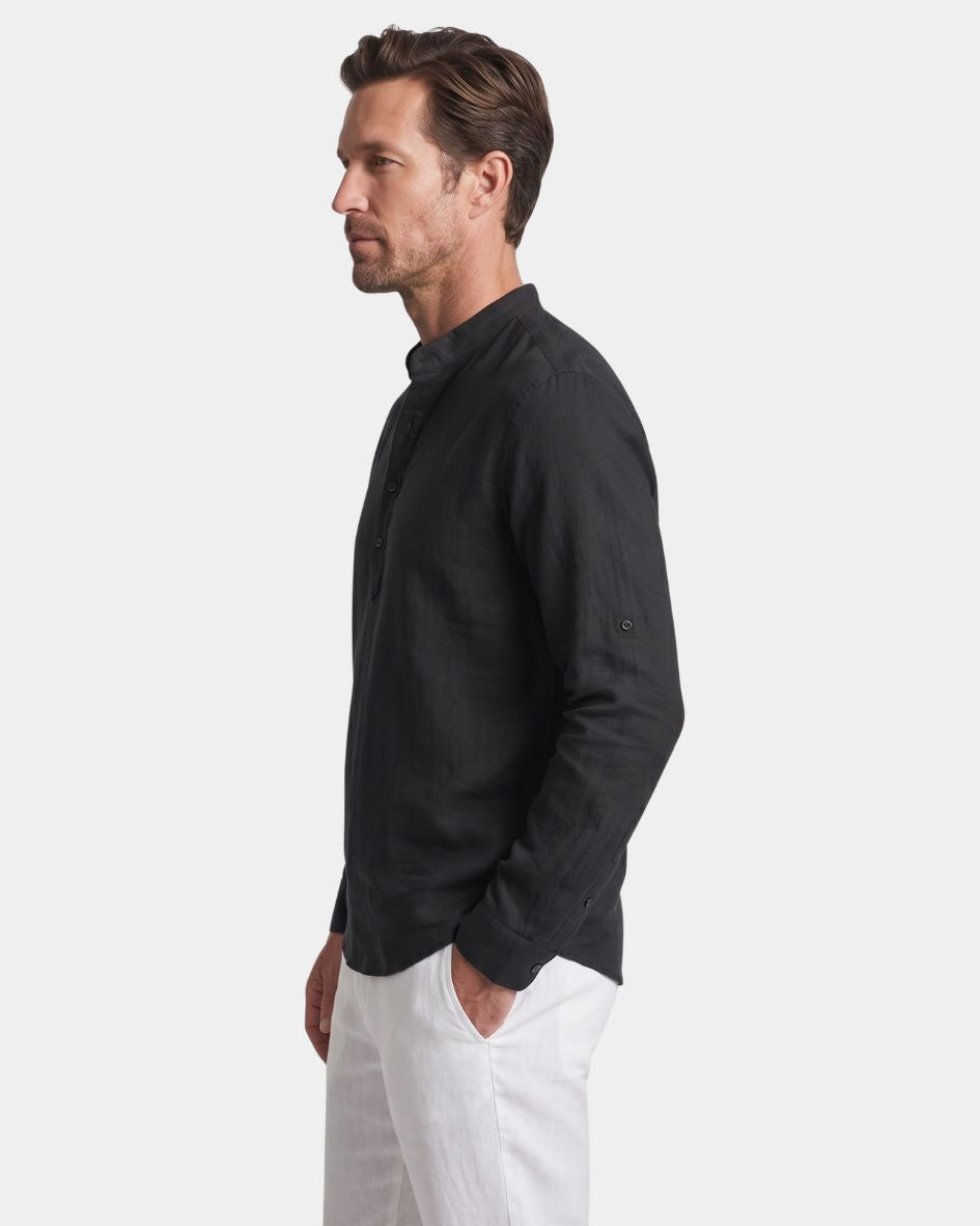 Man wearing a black shirt and white pants on a light gray background