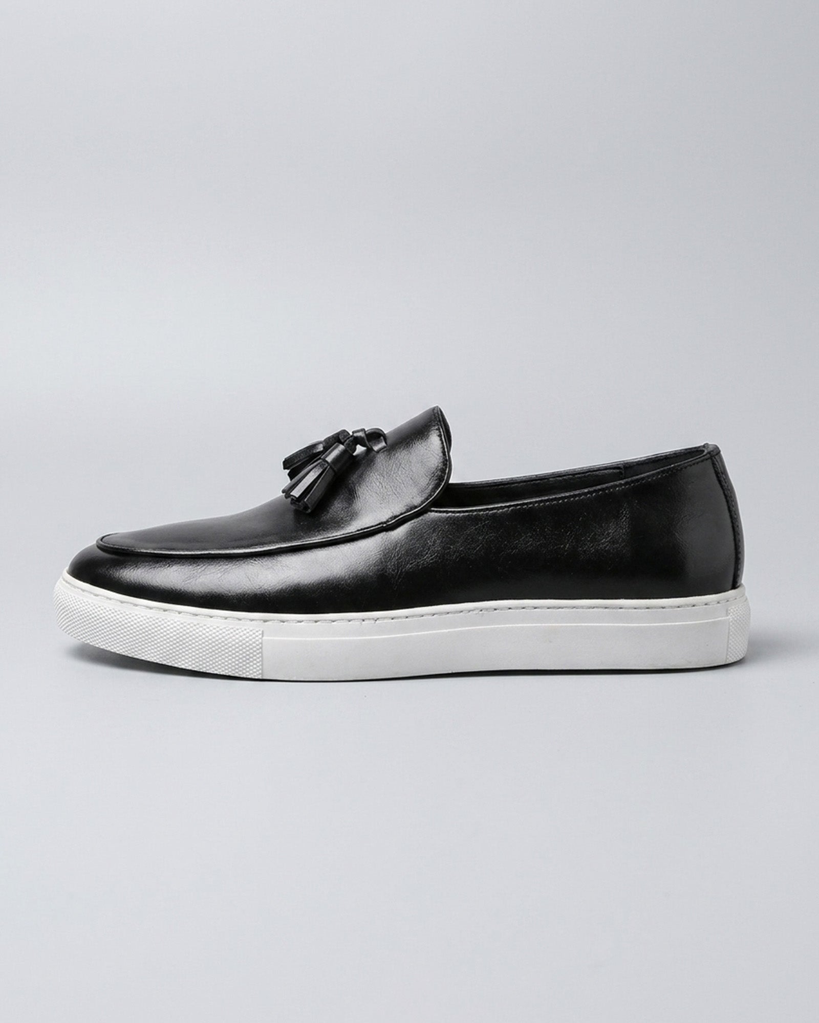 Side view of Capri men's black leather tassel loafer with white cupsole