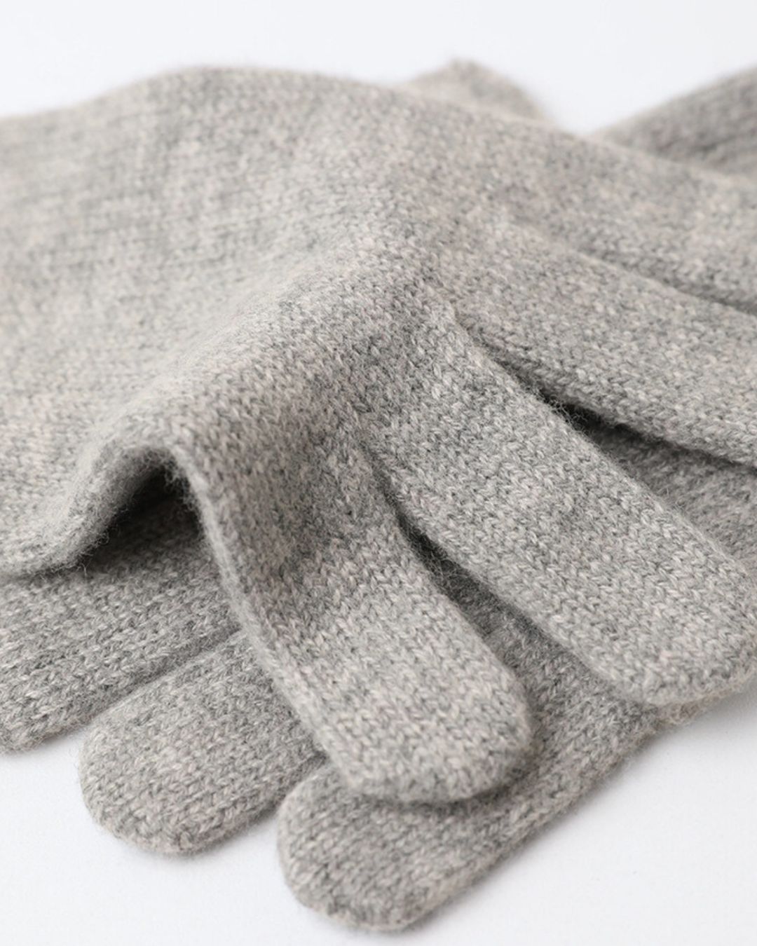 Soft grey cashmere knit gloves with a textured, cozy finish for winter.