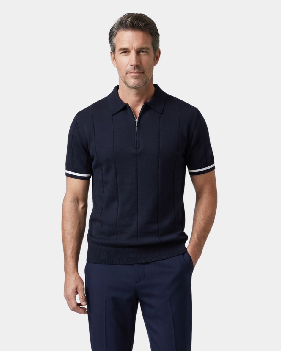 Man wearing a navy polo shirt with white trim on a light gray background