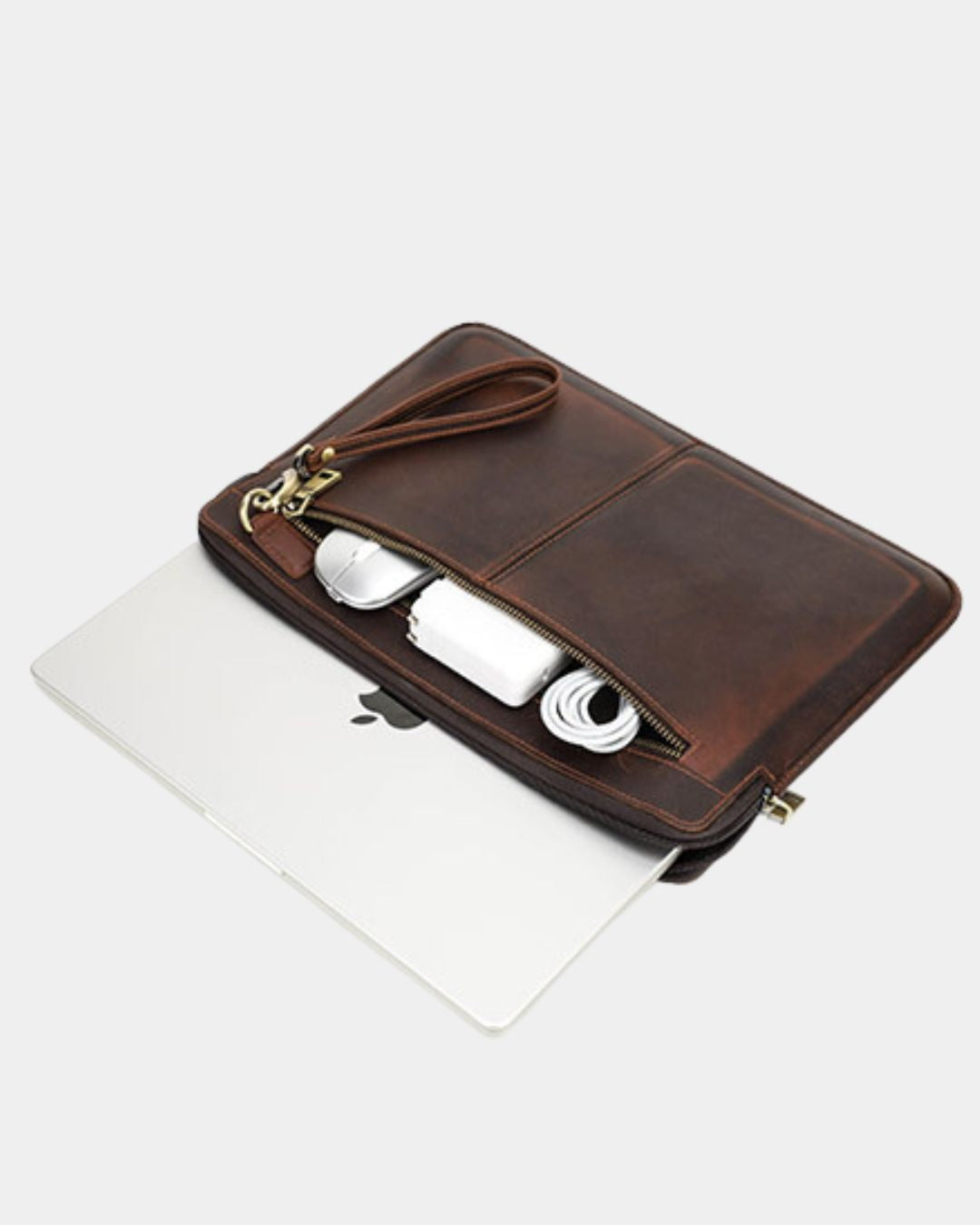 A brown leather laptop sleeve with a wrist strap, shown open with a white laptop and earbud case inside, on a light gray background.
