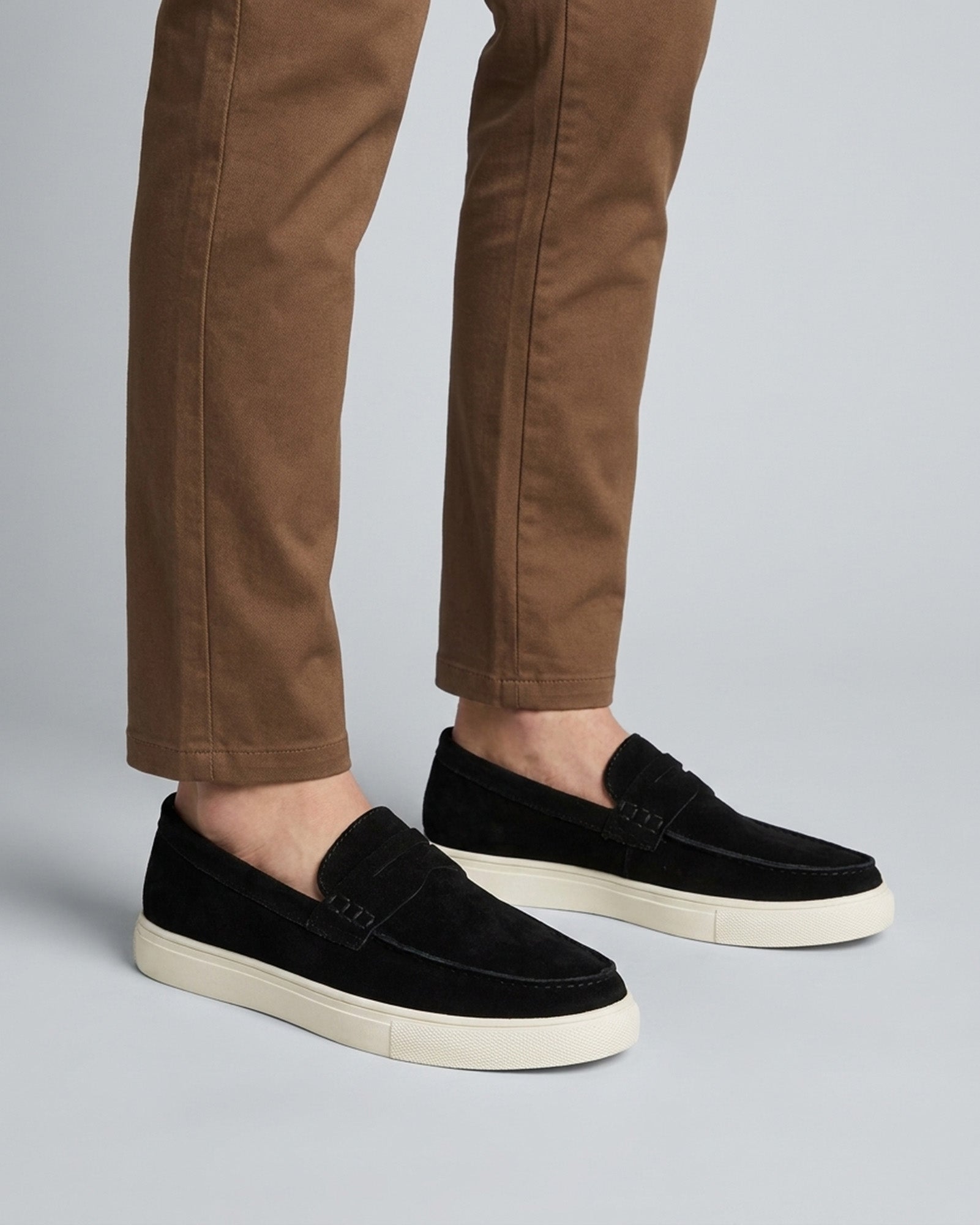 Dunley men's black suede-textured penny loafers worn with brown chinos