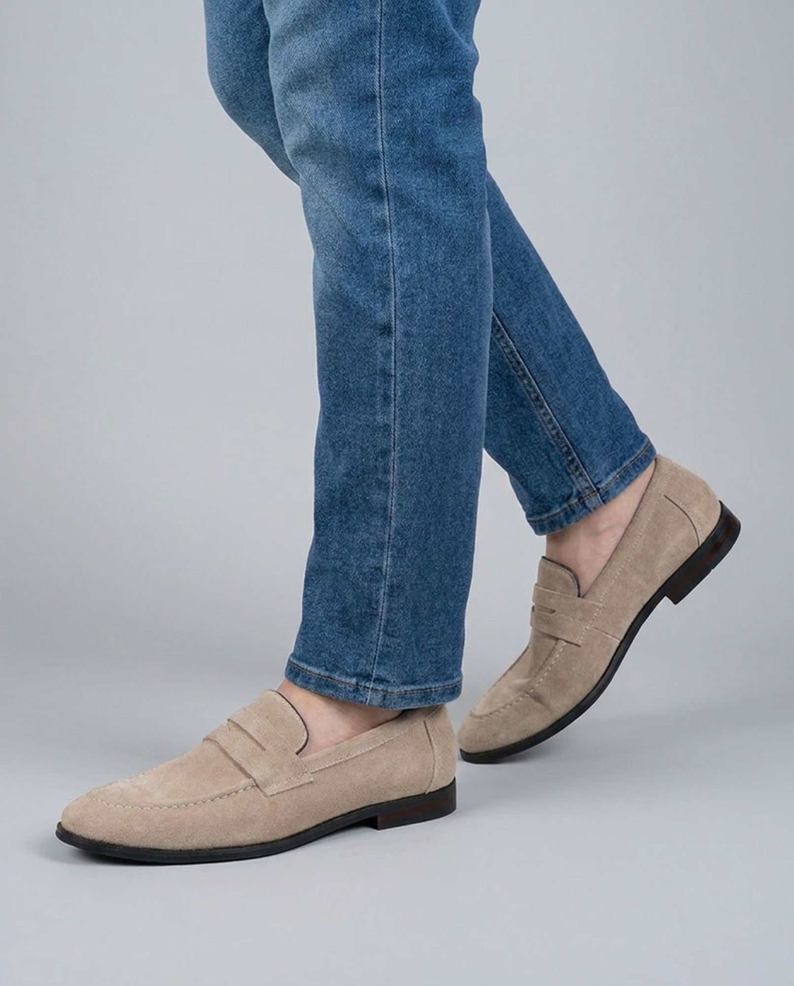 Harper men's beige suede penny loafers mid-stride styled with blue denim jeans