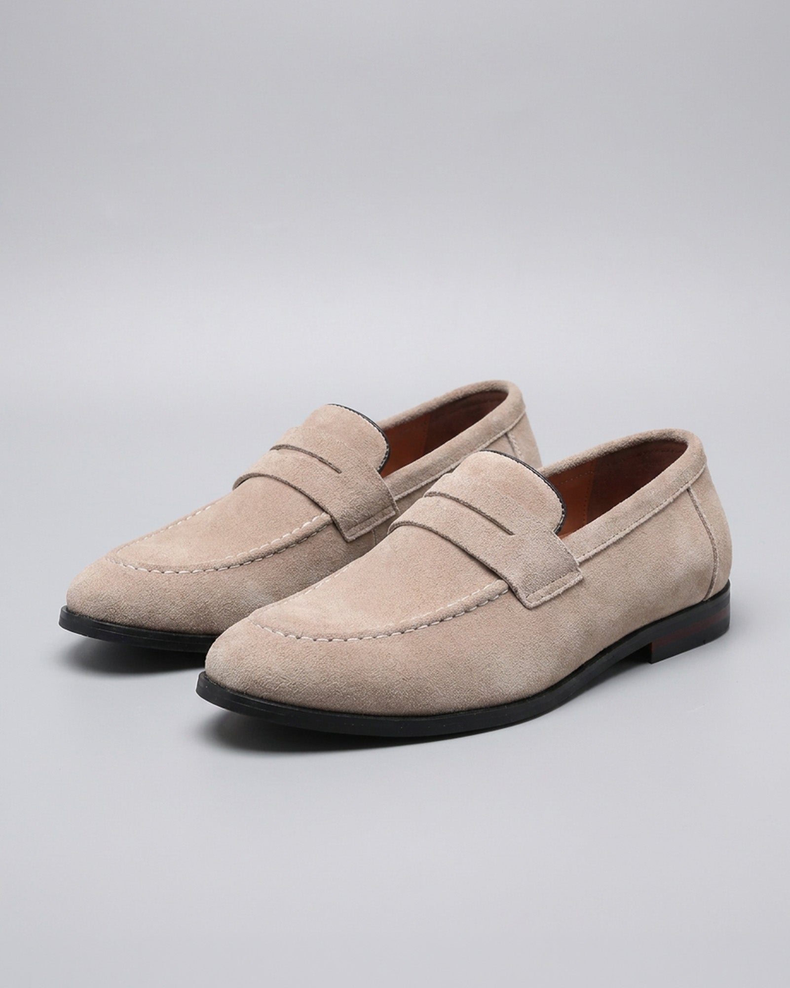 Pair of Harper men's beige suede penny loafers on grey background