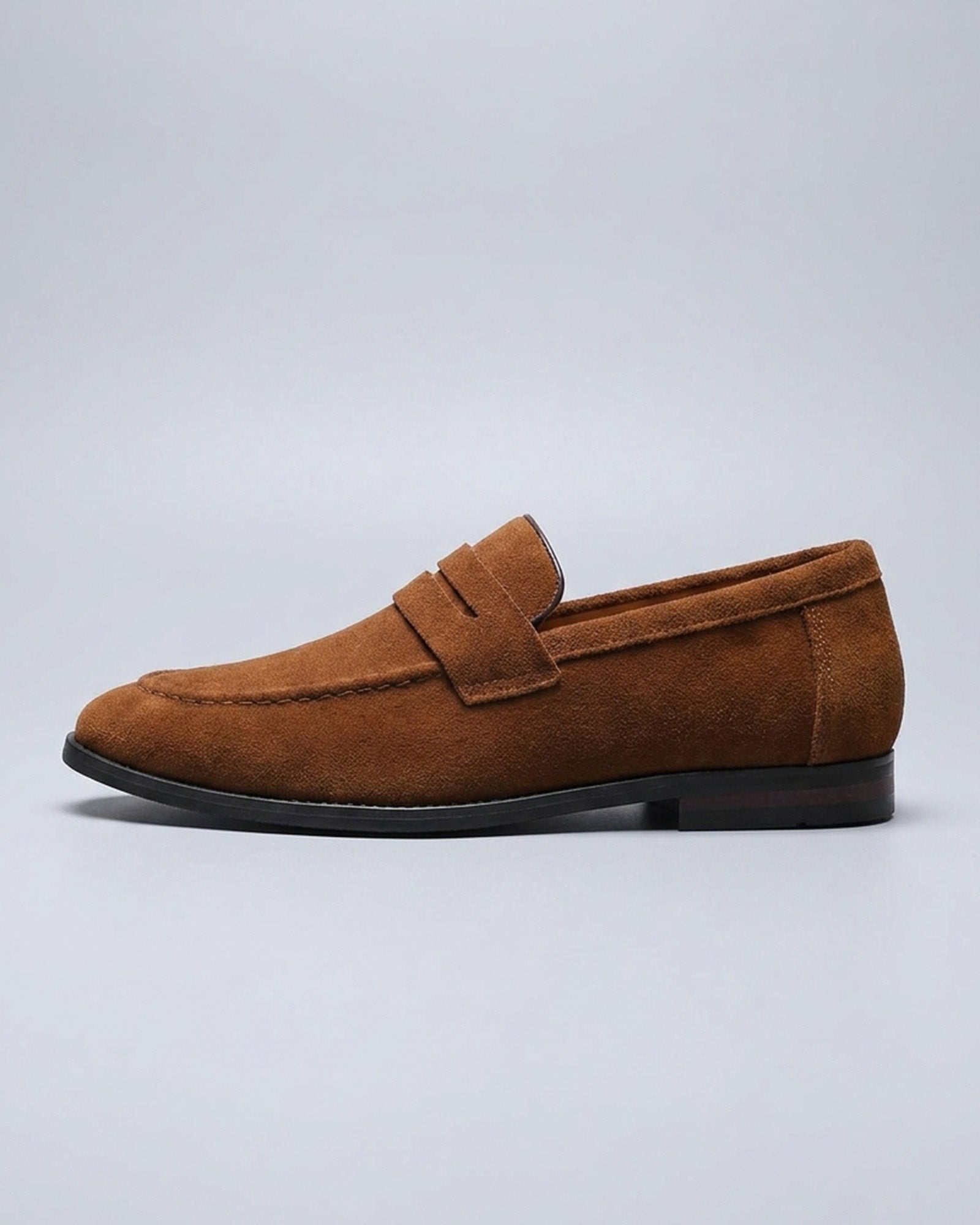 Side view of Harper men's cognac suede penny loafer on grey background