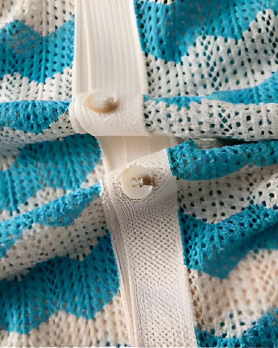 Close-up of a blue and white striped fabric with a button and elastic band.