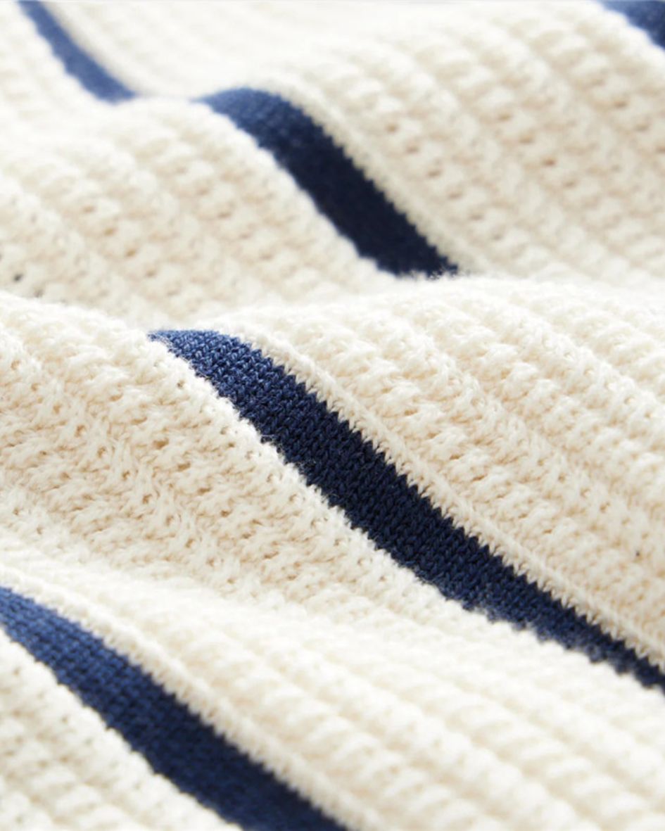 Close-up of a textured fabric with blue stripes on a white background