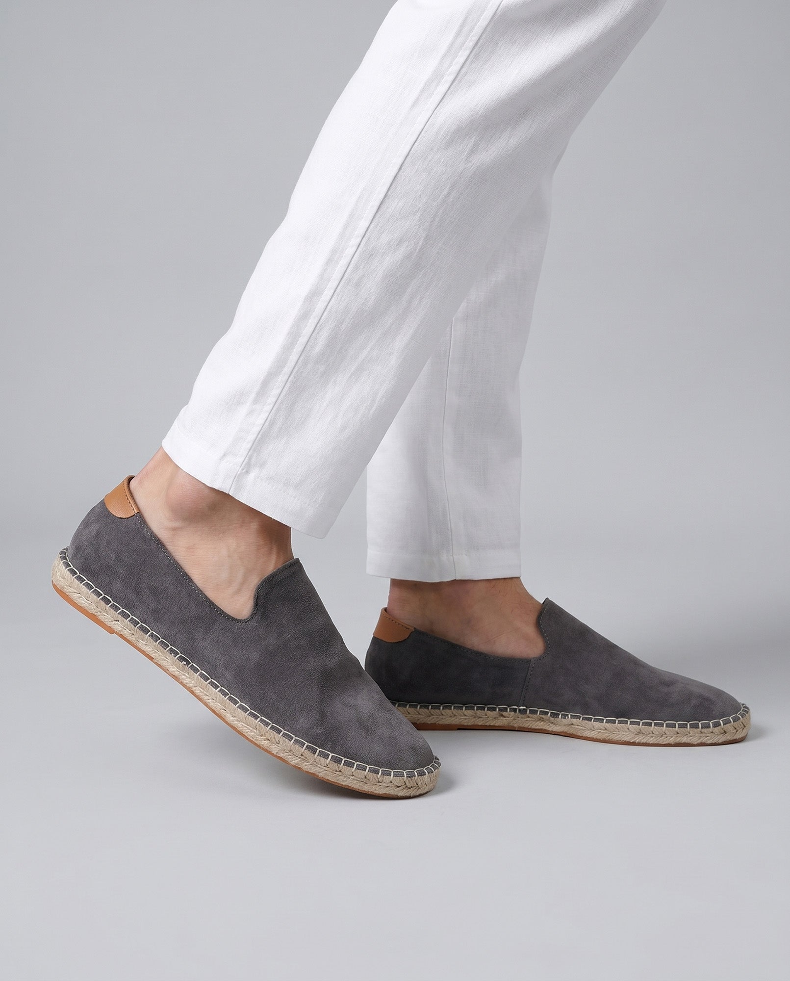 Malaga men's gray suede espadrille loafers worn mid-stride with white linen trousers