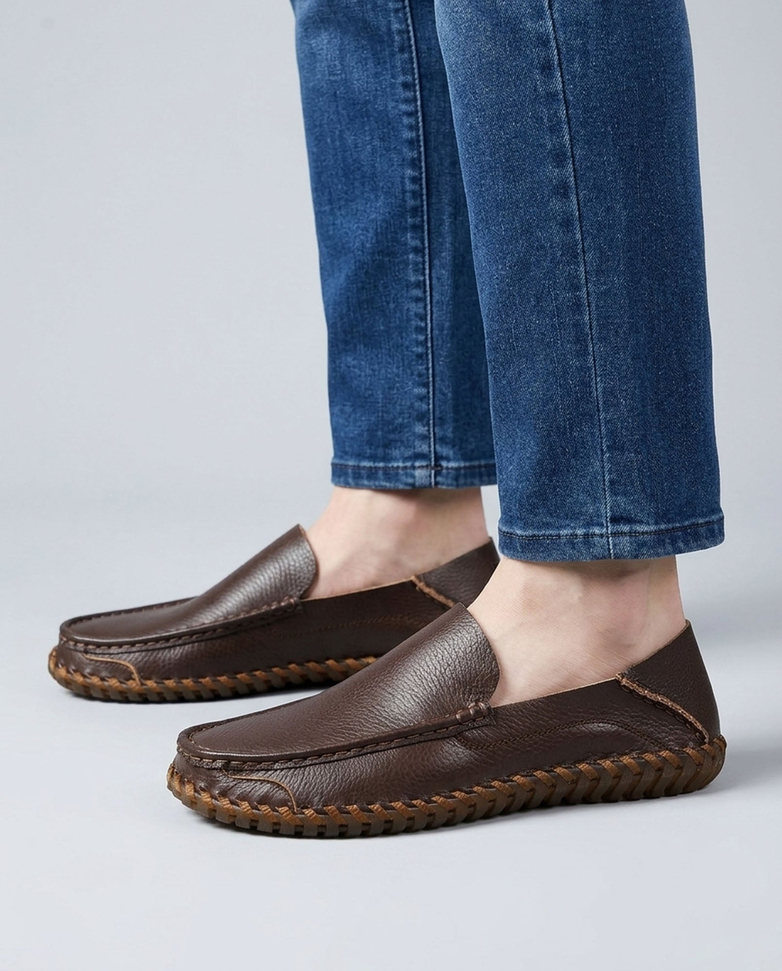 Close-up of Marlow men's dark brown leather driving loafers styled with blue denim jeans