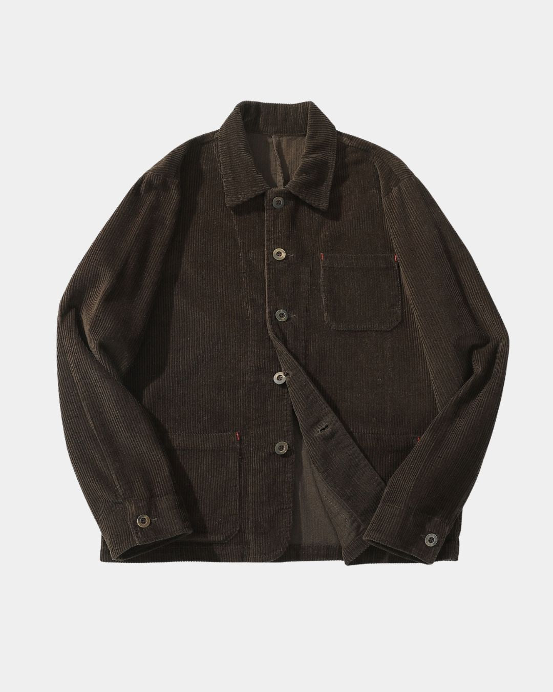 Brown corduroy chore jacket with a point collar, button front, three patch pockets, and red bar-tack stitching details.