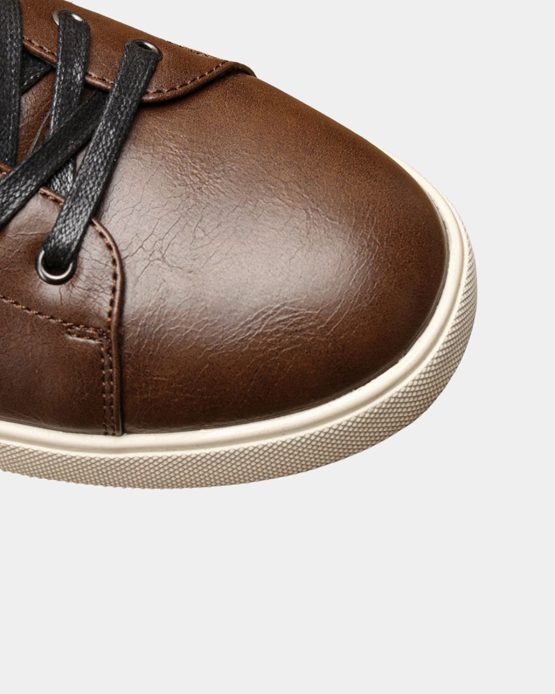 Brown faux leather low top dress sneaker with black laces and a textured cream rubber sole.