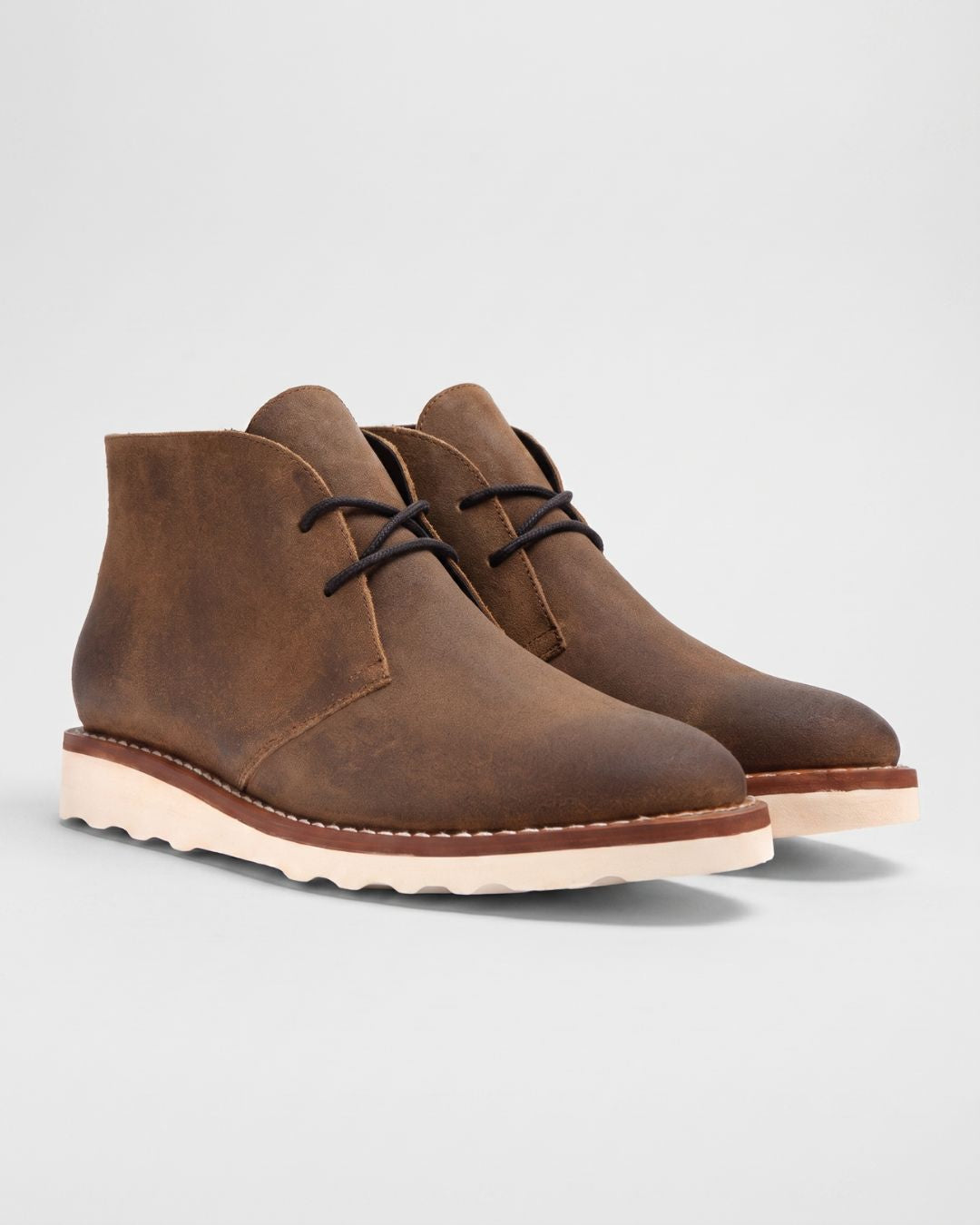 Men's brown faux leather chukka boots with a chunky white sneaker-inspired foam sole and lace-up ankle design.