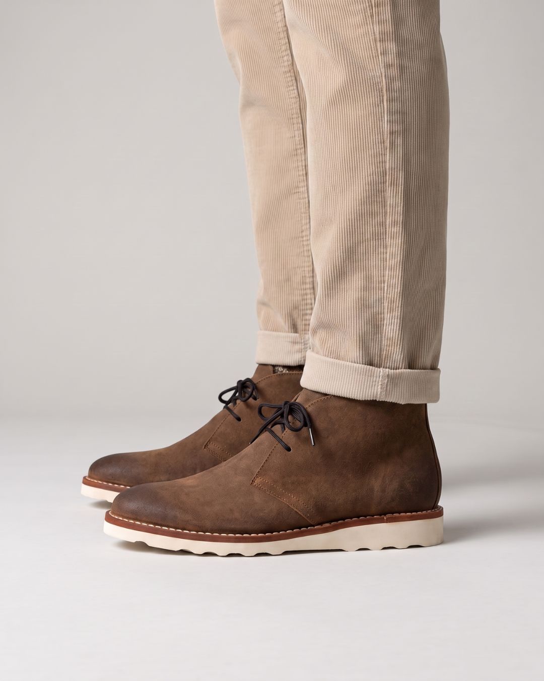 Men’s brown faux leather chukka boots with a chunky white sneaker-inspired foam sole and lace-up ankle design.