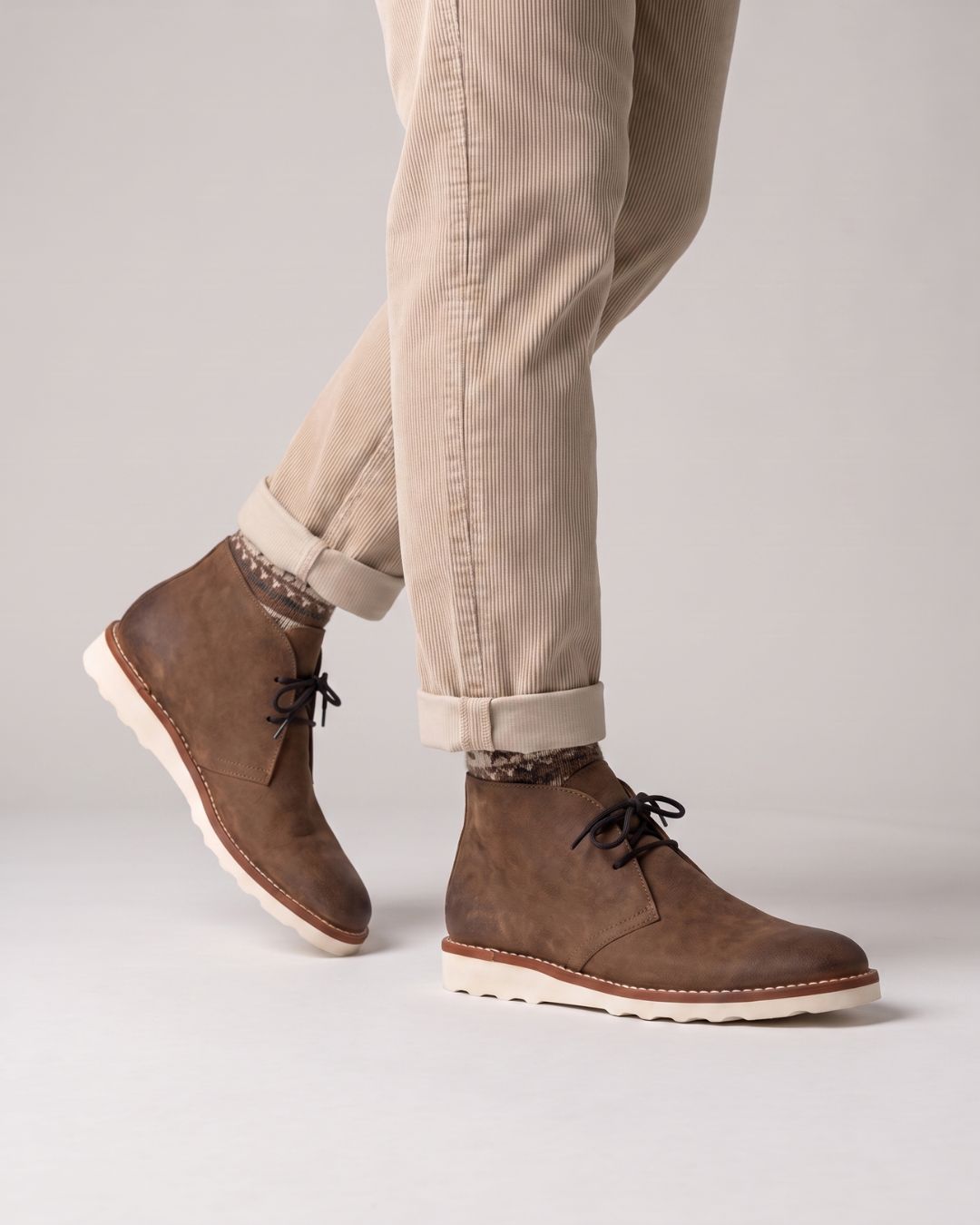 Men’s brown faux leather chukka boots with lace-up closure and a chunky white sneaker-style foam outsole.