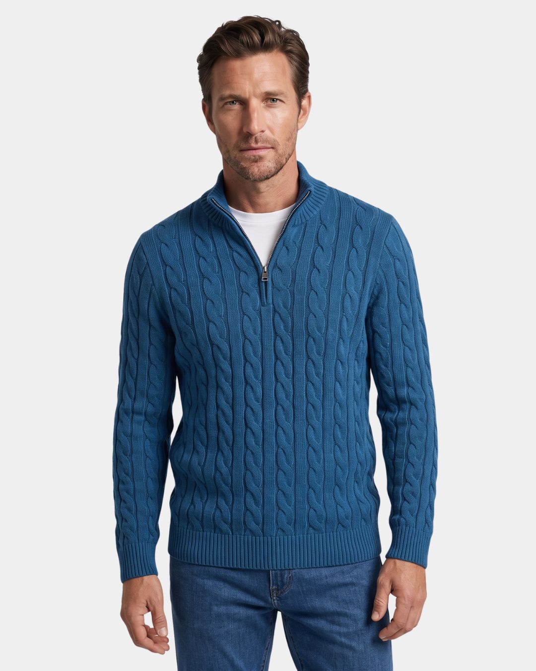 Man wearing a blue cotton cable knit quarter-zip sweater with a mock-neck collar and ribbed cuffs.