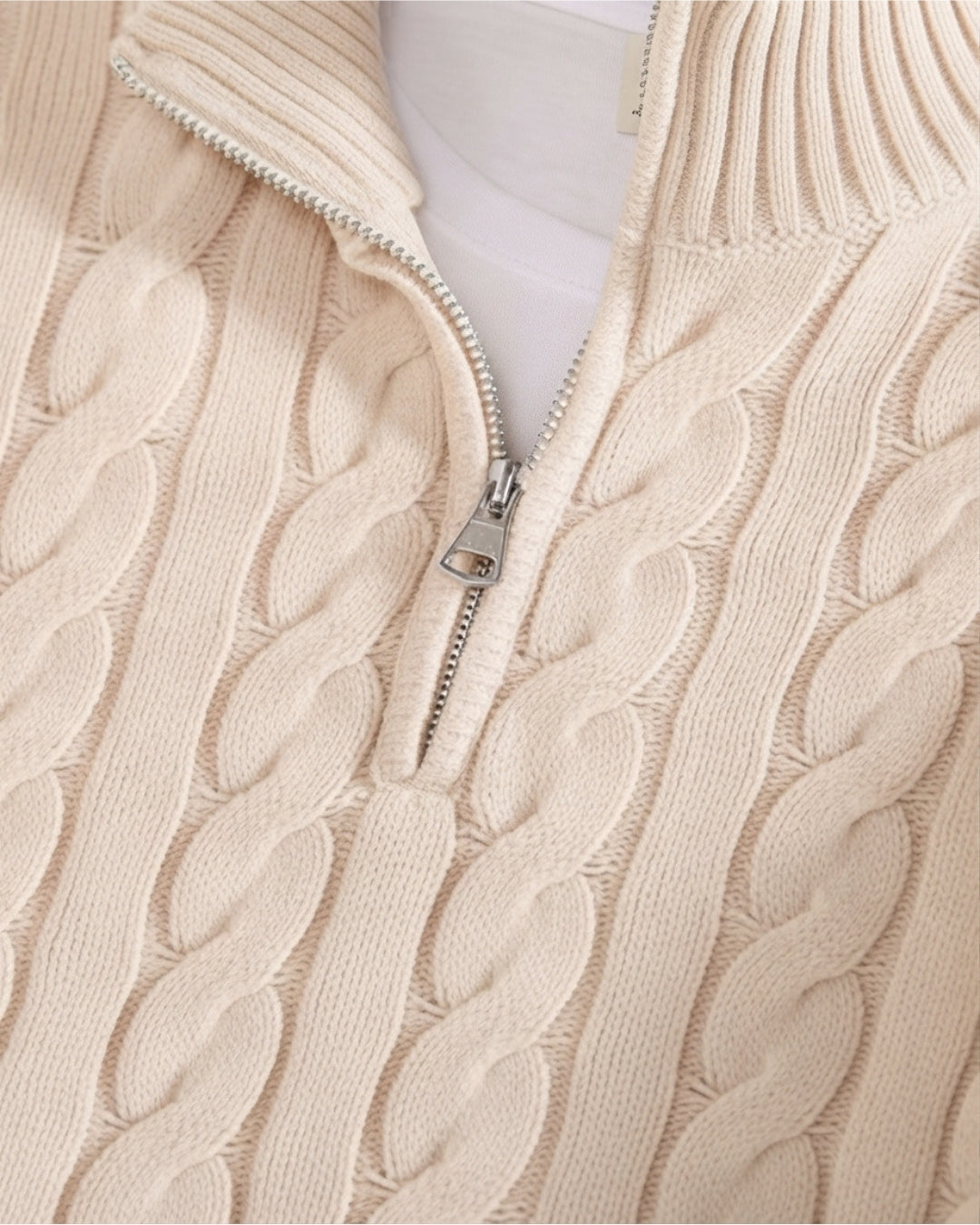 Cream-colored cotton cable knit quarter-zip sweater with a mock-neck collar and silver metal zipper detail.