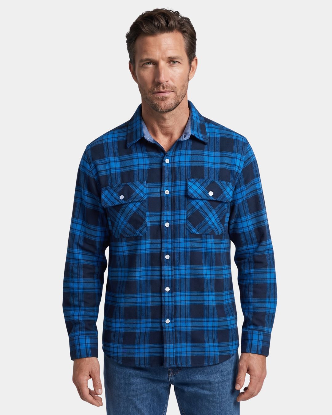 Man wearing a blue and navy plaid long-sleeve flannel shirt with two chest pockets and a button-front design.