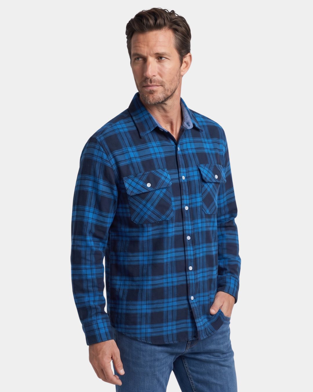 Man wearing a blue and navy plaid brushed flannel shirt with two chest pockets and a button-front design.