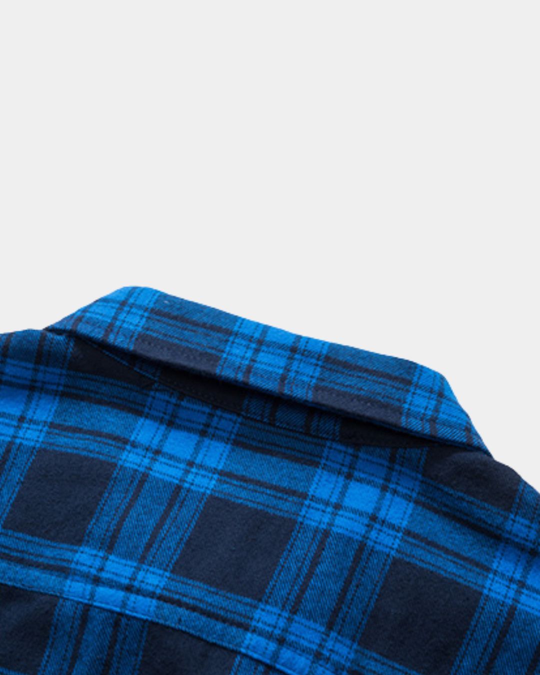 Close-up of a men's blue and black plaid flannel shirt featuring a soft brushed fabric and classic collar design.