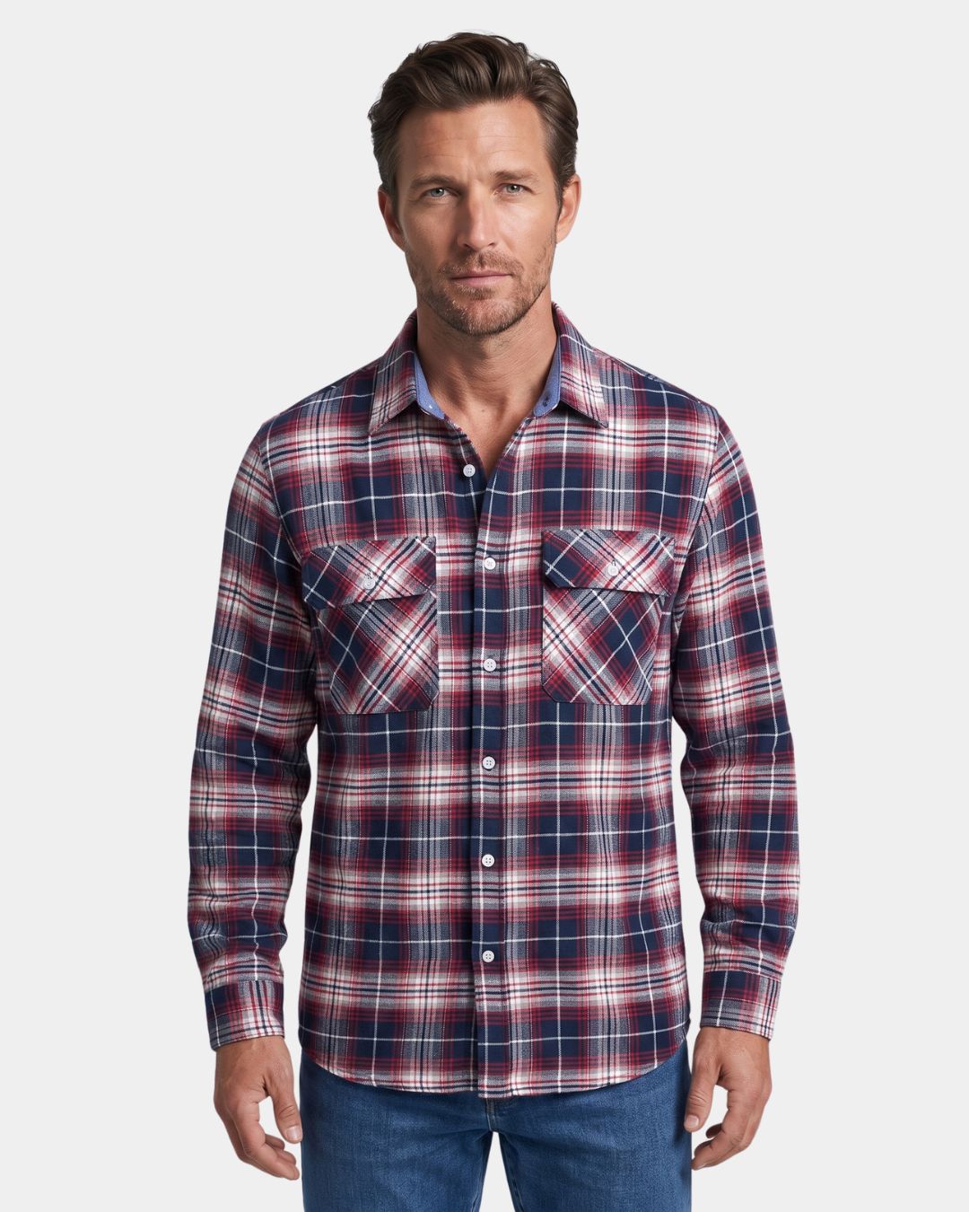Man wearing a soft, brushed flannel shirt with a red and navy plaid pattern, button-front, and dual chest pockets.