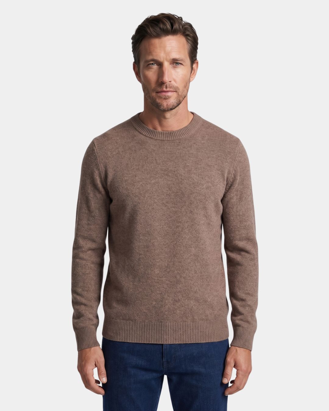 Man wearing a brown 100% wool crew neck sweater with ribbed cuffs and hem, styled with blue jeans.