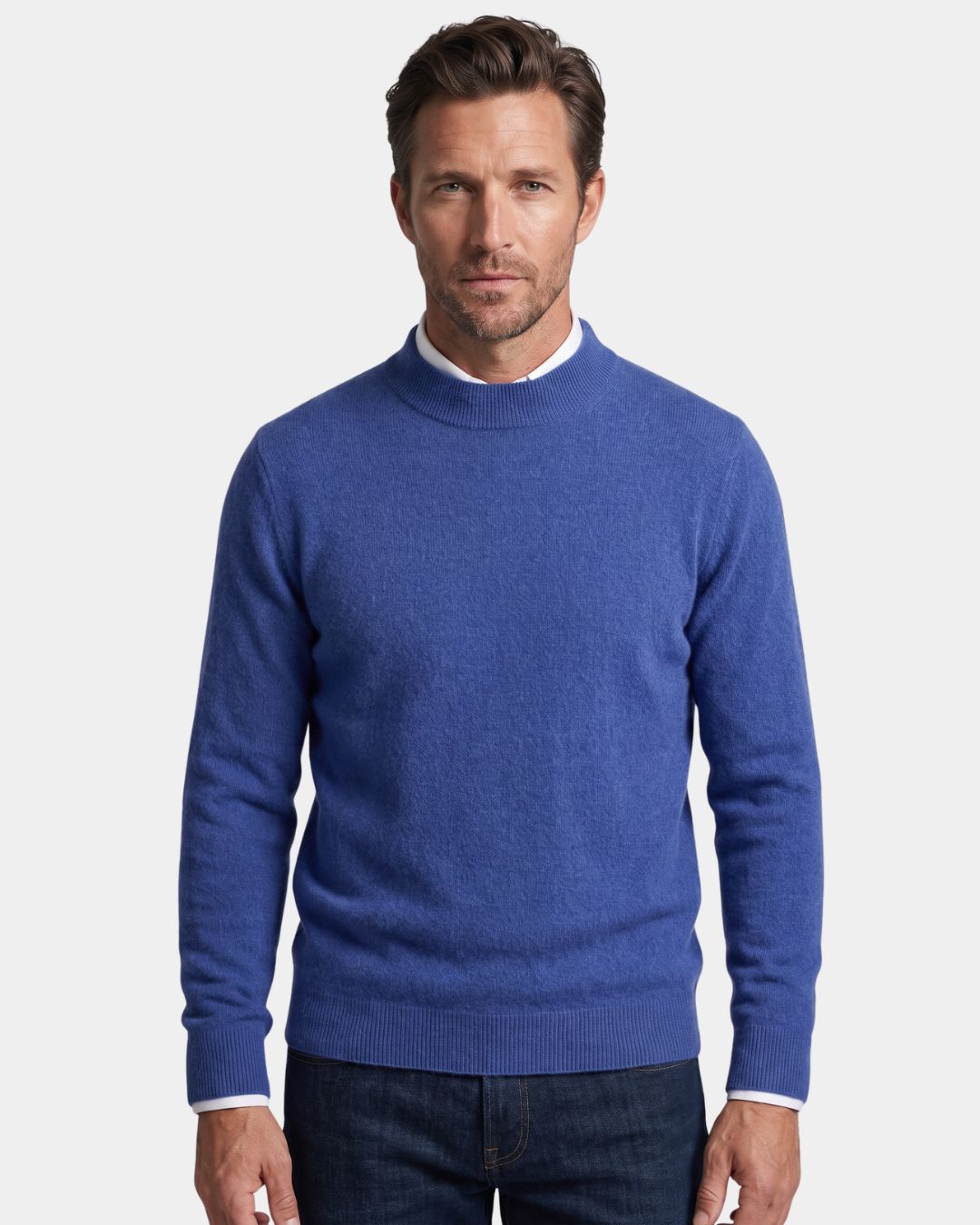 Man wearing a blue 100% wool mock neck sweater with ribbed cuffs and a relaxed fit over a white collared shirt.