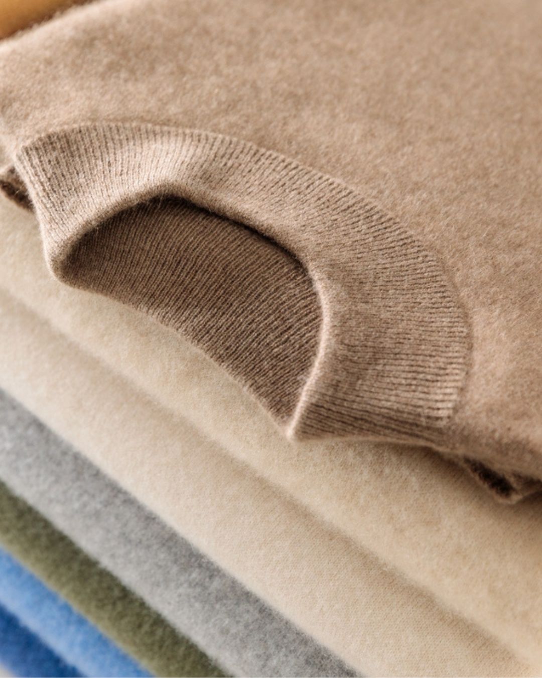 Stacked tan wool mock neck sweater with a soft knit texture and ribbed collar detail.