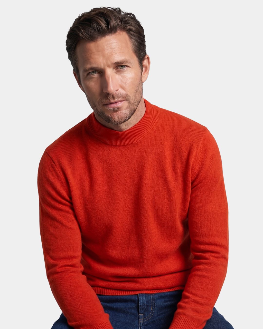 Man wearing a vibrant red 100% wool mock neck sweater with a soft knit texture and ribbed collar.