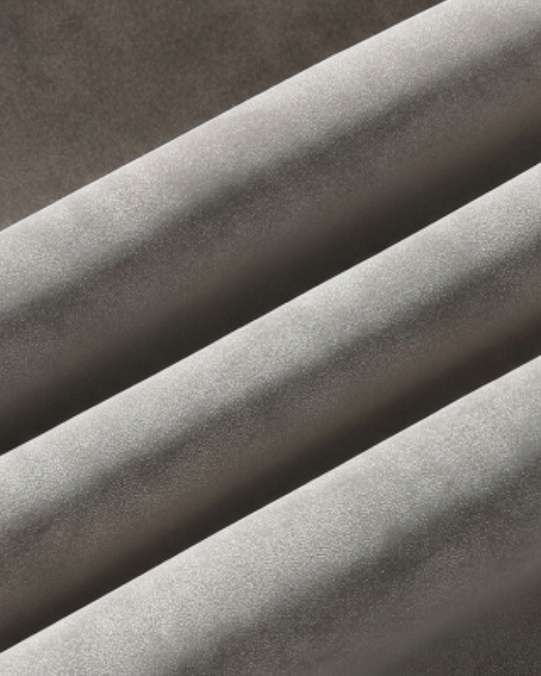A close-up of a light gray fabric with a soft, slightly textured surface, draped diagonally across the frame.