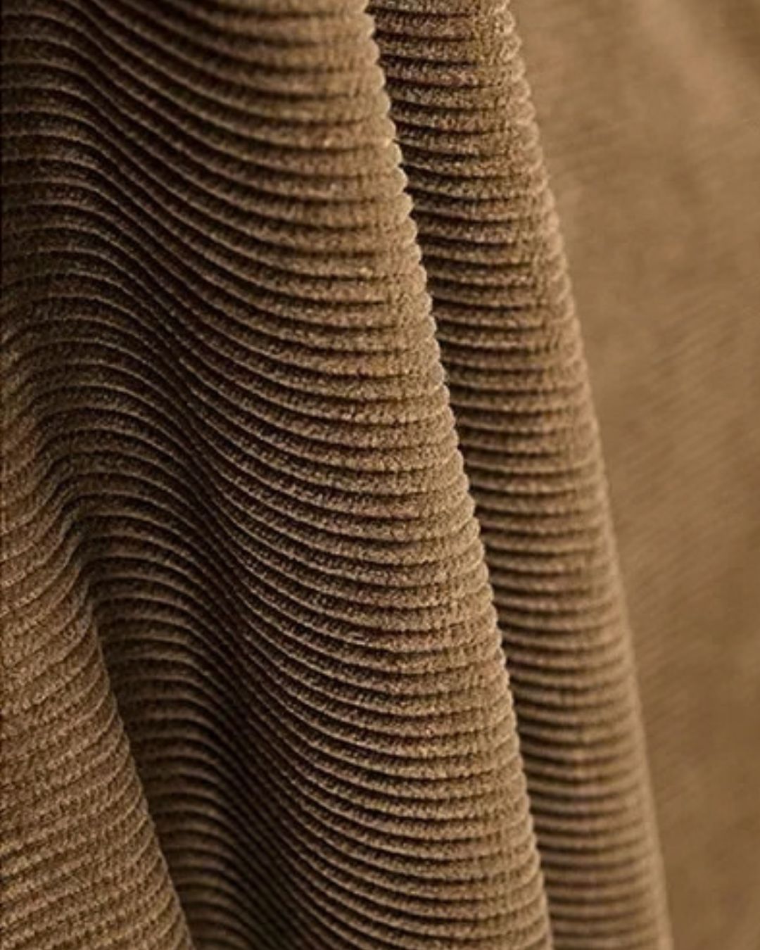 Close-up of brown corduroy fabric with distinct vertical ridges and soft texture for a men's trucker jacket.