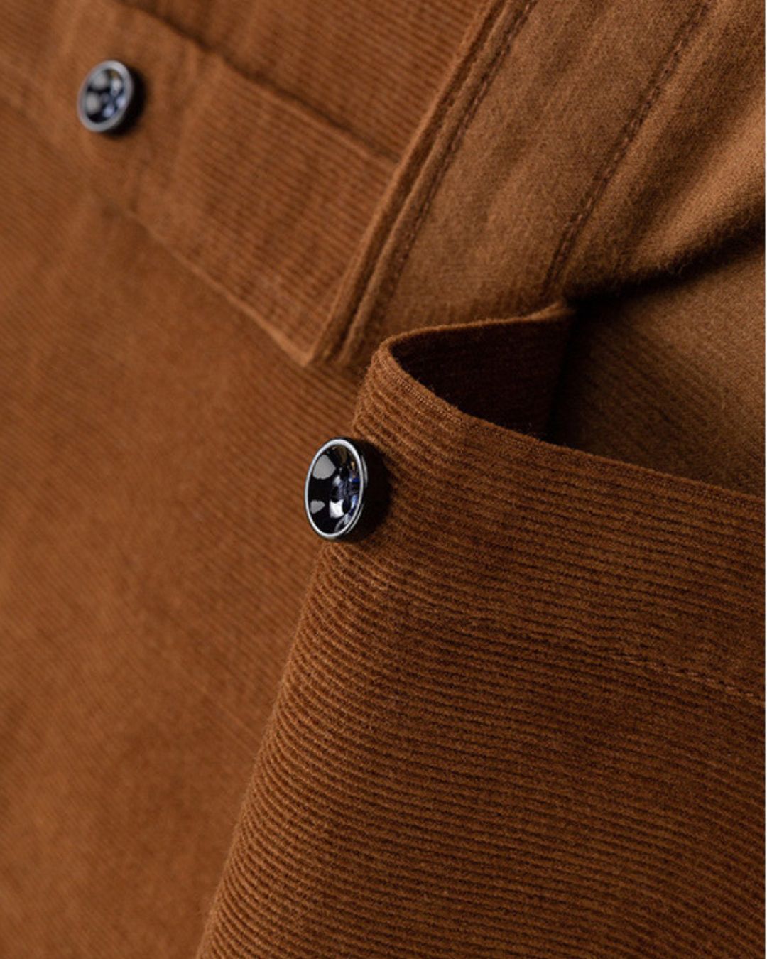 Close-up of a brown cotton corduroy shirt featuring a ribbed texture, button-down collar, and a single chest pocket.