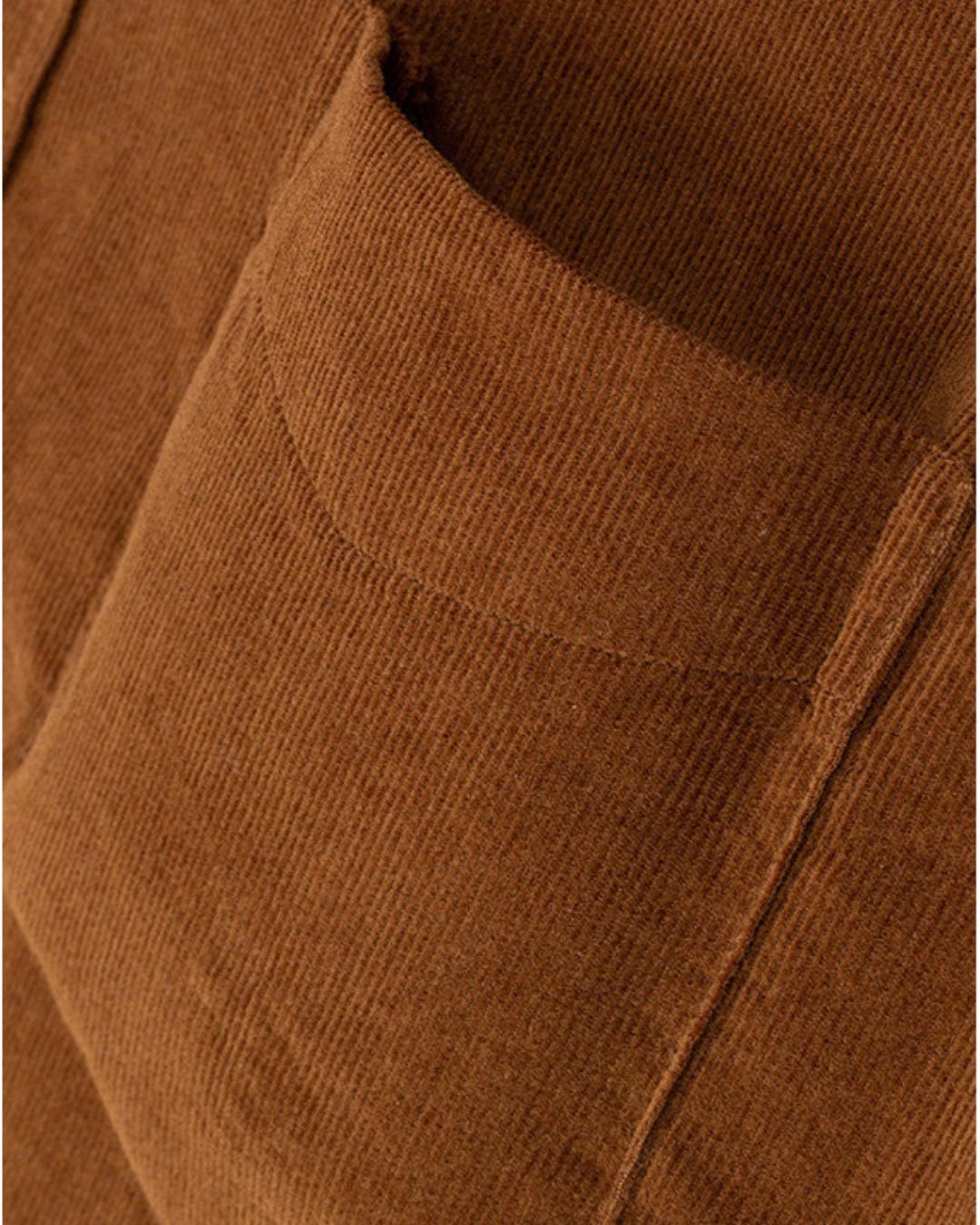 Close-up of a brown cotton corduroy shirt featuring a soft ribbed texture and a single chest pocket.