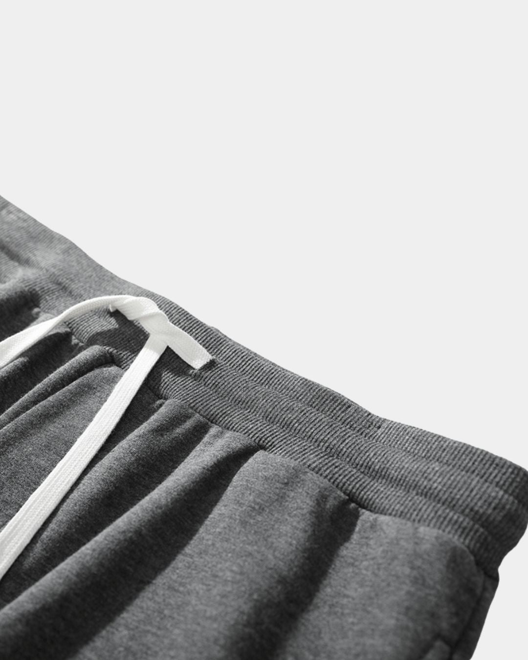 Grey cotton jogger sweatpants featuring an elastic drawstring waist and soft, mid-weight fabric texture.