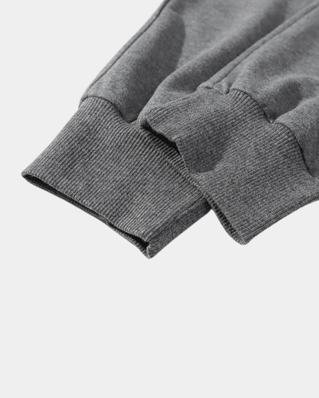 Close-up of charcoal grey cotton jogger sweatpants featuring ribbed, tapered ankle cuffs.