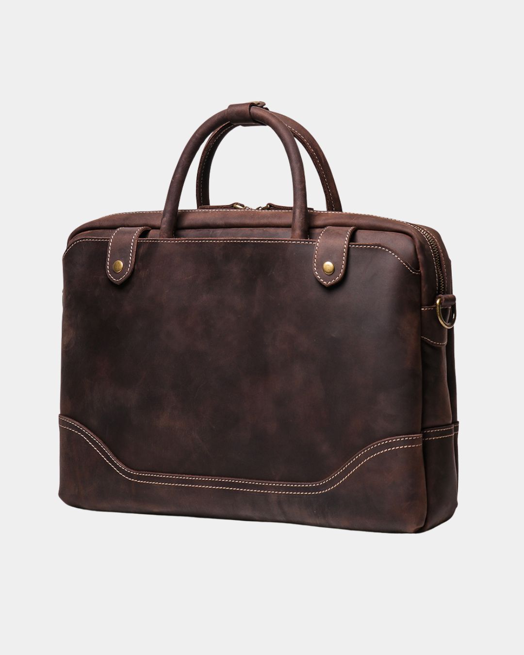 A dark brown distressed leather briefcase with dual top handles, brass snap buttons, and contrast stitching, shown on a light gray background.