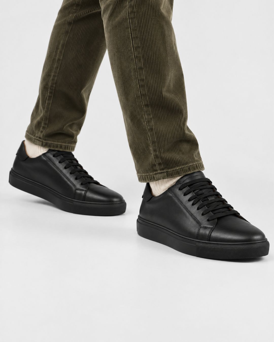 Men's black genuine leather low-top dress sneakers with a lace-up closure and durable rubber outsole.