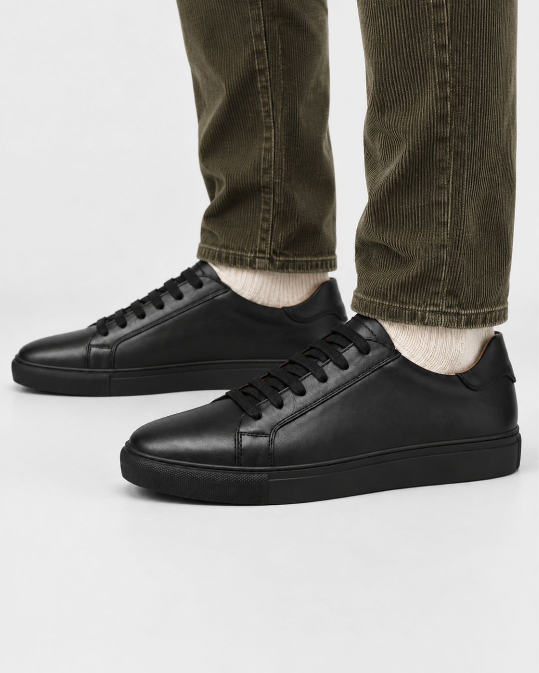 Men’s black genuine leather low-top dress sneakers with matching laces and a durable rubber outsole.