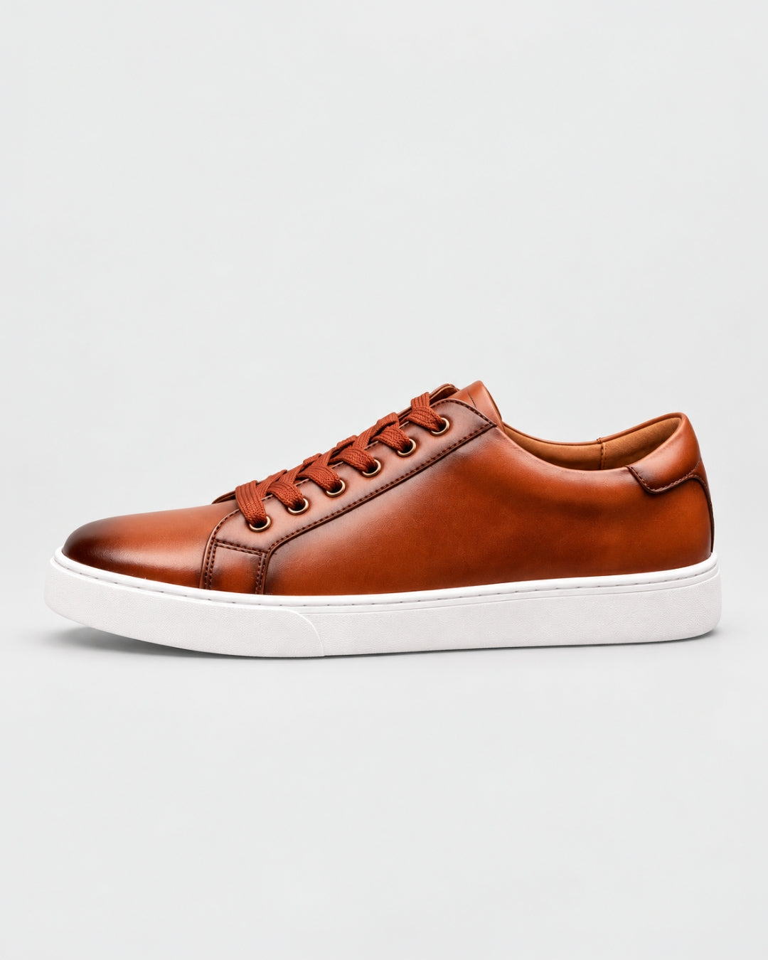 Cognac genuine leather low-top dress sneaker with matching laces and a clean white rubber outsole.