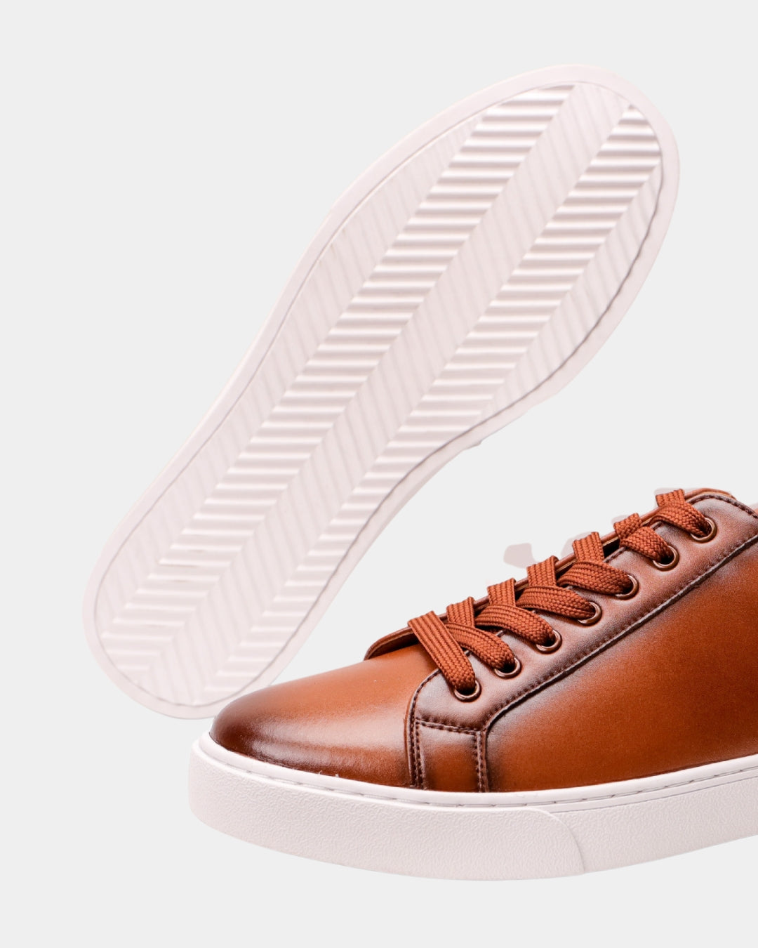 Cognac genuine leather low-top dress sneaker with matching laces and a durable white rubber outsole.